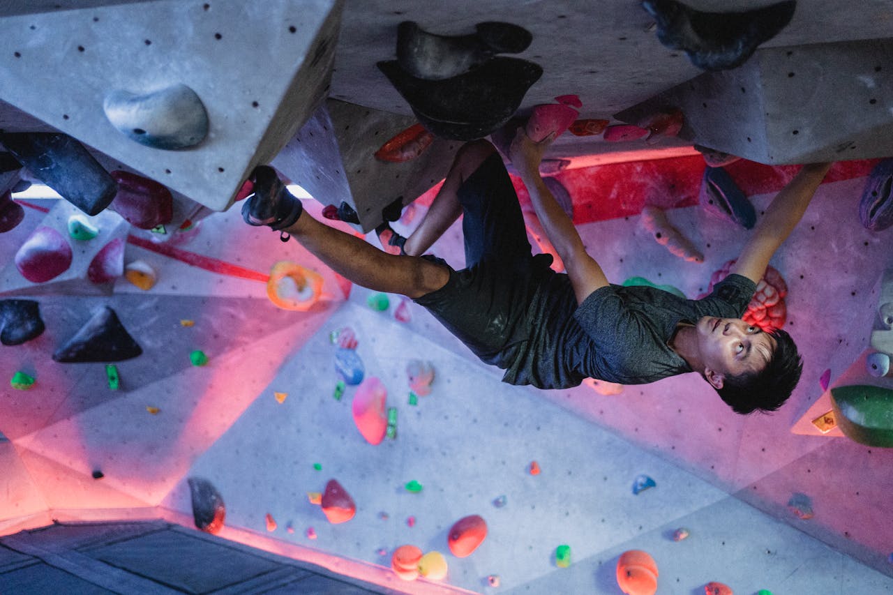 Ethnic man training in bouldering gym
